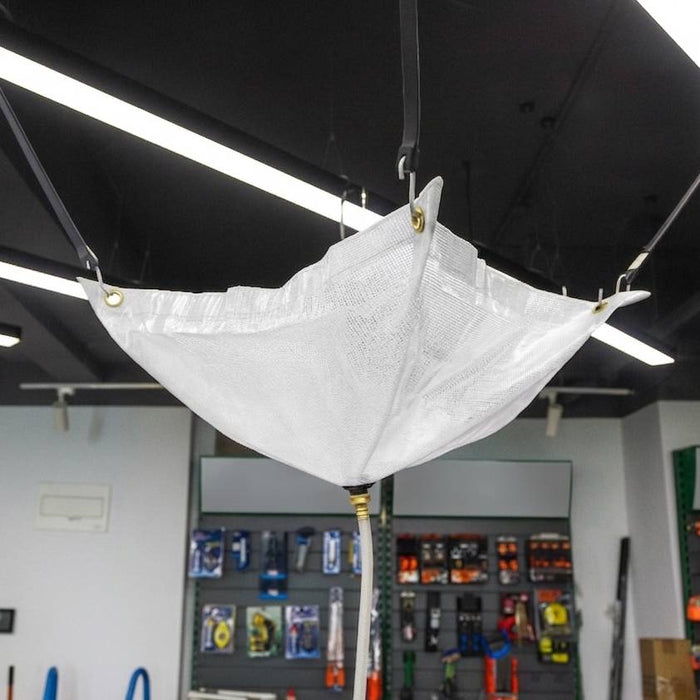 White safety net hanging from a ceiling in a workshop setting